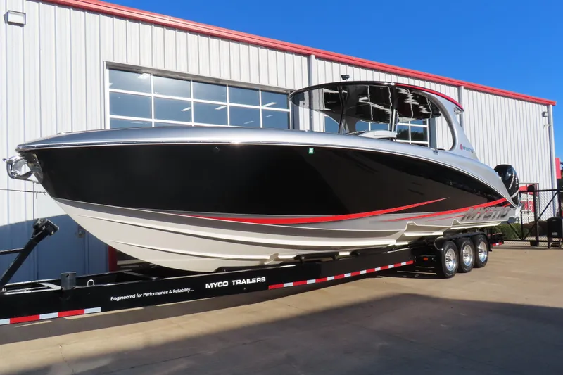 Slide: The Image of 2017 Mystic M4200 boat on trailer outside a warehouse, showcasing sleek design. - 3