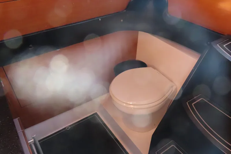 Slide: The Image of Interior of 2017 Mystic M4200 boat featuring a compact marine toilet. - 30