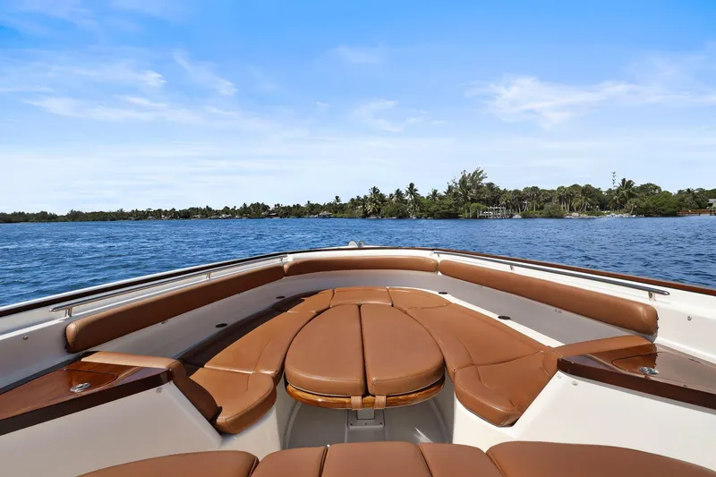 Slide: The Image of 2023 HCB 65 Estrella boat interior with brown seating, on a calm blue lake. - 23