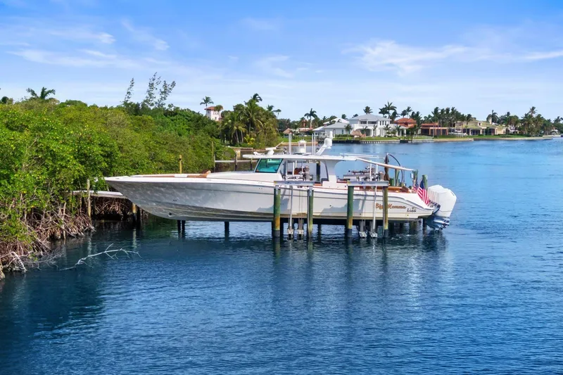 Slide: The Image of 2023 HCB 65 Estrella boat docked in a scenic waterfront setting. - 31