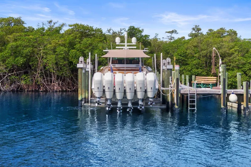 Slide: The Image of 2023 HCB 65 Estrella docked with multiple outboard engines, surrounded by lush greenery. - 6