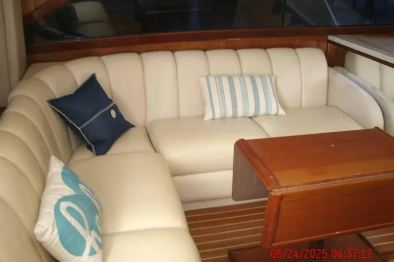 Slide: The Image of Luxurious interior of 1998 Ocean Yachts 48 Super Sport with plush seating and wooden table. - 14
