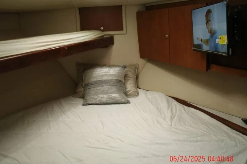 Slide: The Image of Cozy cabin interior of 1998 Ocean Yachts 48 Super Sport with bed, TV, and wooden cabinets. - 16