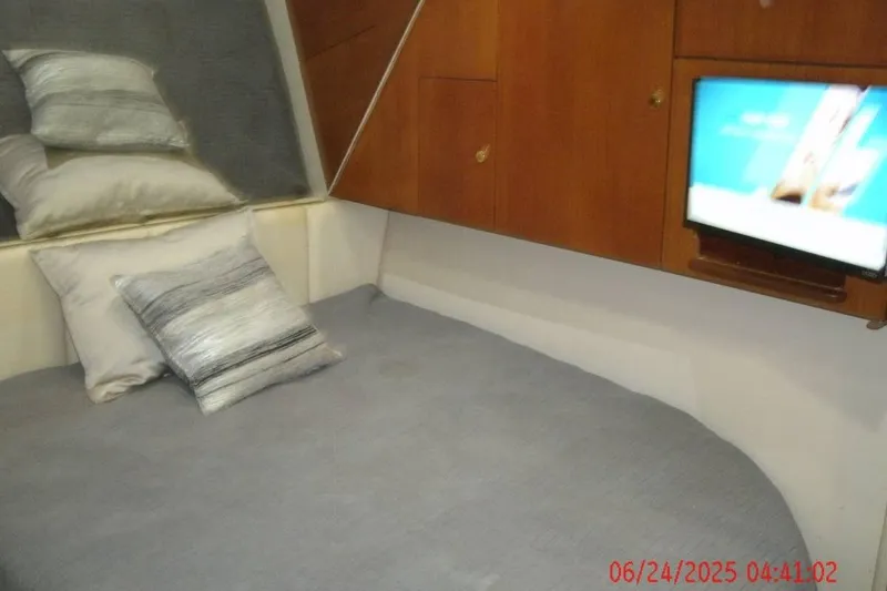 Slide: The Image of Cozy cabin interior of 1998 Ocean Yachts 48 Super Sport with bed, pillows, and mounted TV. - 17