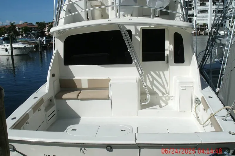 Slide: The Image of 1998 Ocean Yachts 48 Super Sport boat docked at marina, featuring spacious deck and seating area. - 4