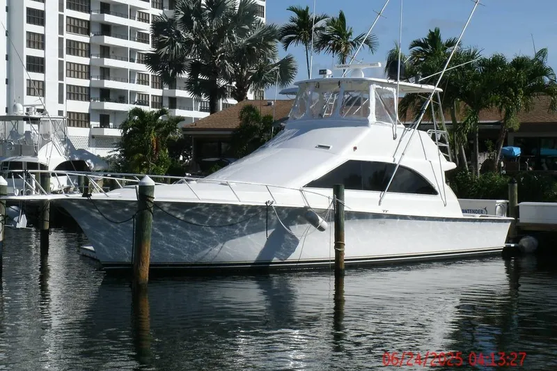 The Image of 1998 Ocean Yachts 48 Super Sport docked near palm trees and buildings. - 1
