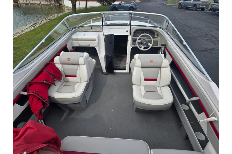 Slide: The Image of 1994 Four Winns 235 Sundowner boat interior with white and red seating, steering wheel, and dashboard. - 10