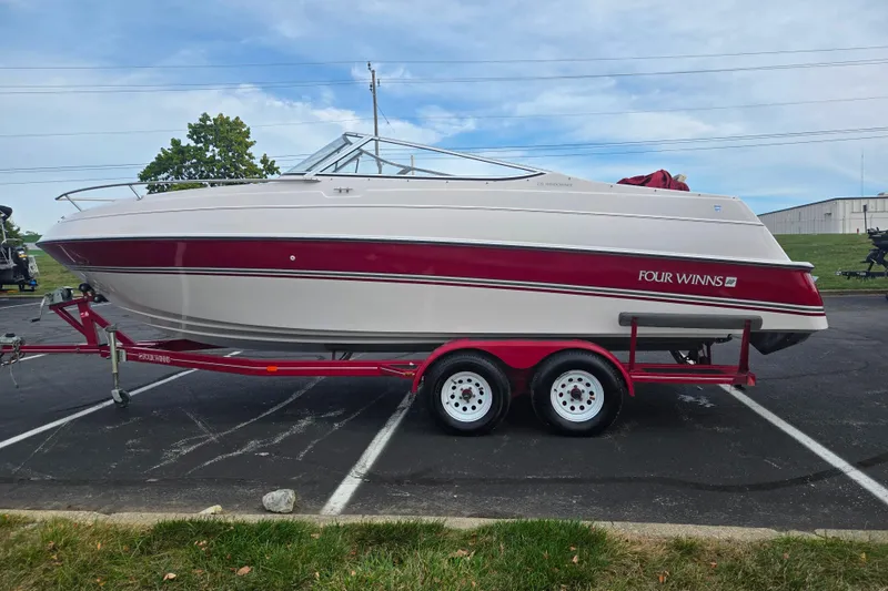 Slide: The Image of 1994 Four Winns 235 Sundowner boat on trailer, red and white design, parked outdoors. - 4