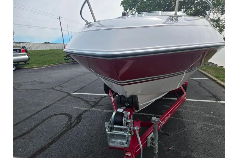Slide: The Image of 1994 Four Winns 235 Sundowner boat on trailer in parking lot. - 6