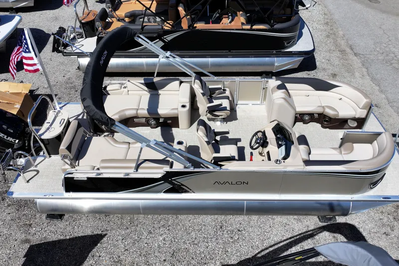 Slide: The Image of 2026 Avalon LSZ Quad Lounger Shift pontoon boat with beige seating and American flag. - 14