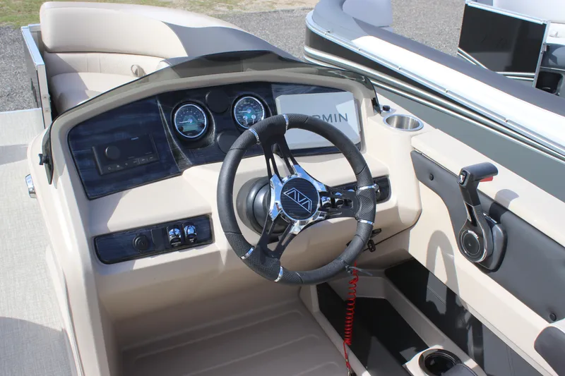 Slide: The Image of 2026 Avalon LSZ Quad Lounger Shift boat dashboard with steering wheel and controls. - 8