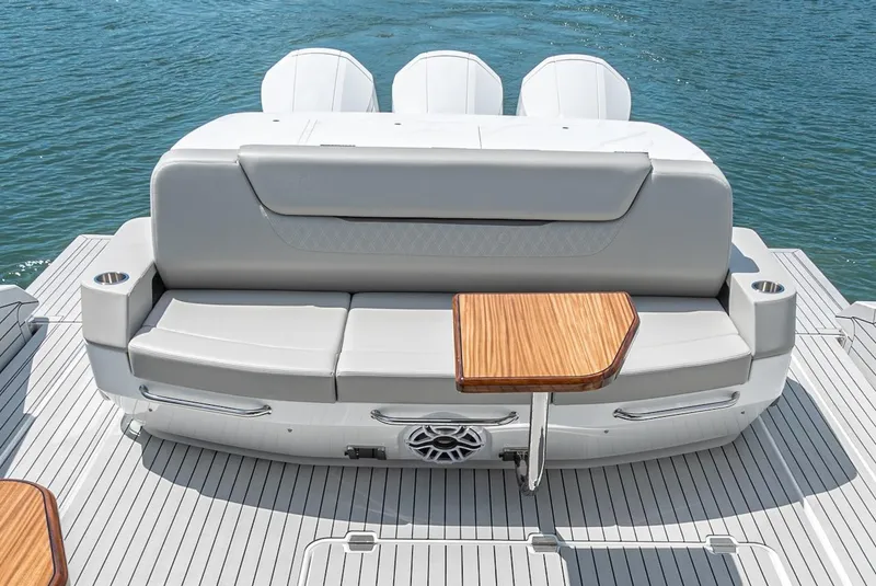 Slide: The Image of 2024 Cruisers Yachts 50 GLS rear seating area with wooden table on deck. - 26