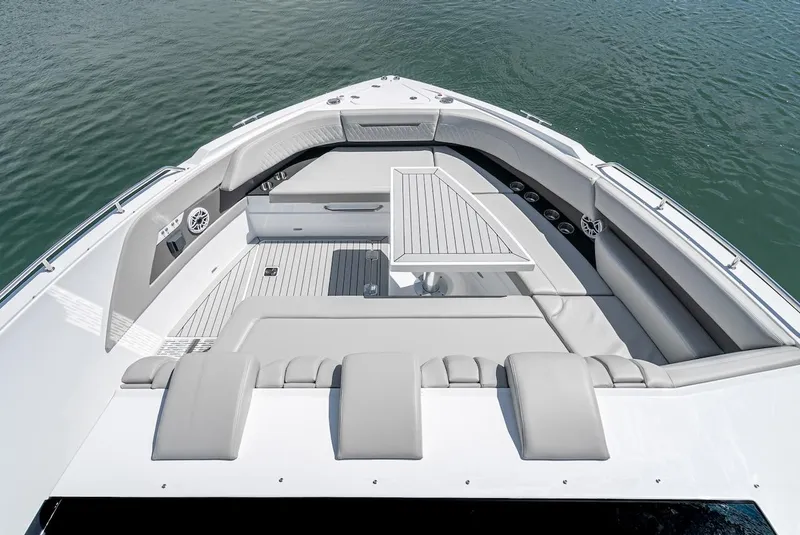 Slide: The Image of 2024 Cruisers Yachts 50 GLS bow seating area with table on calm water. - 18