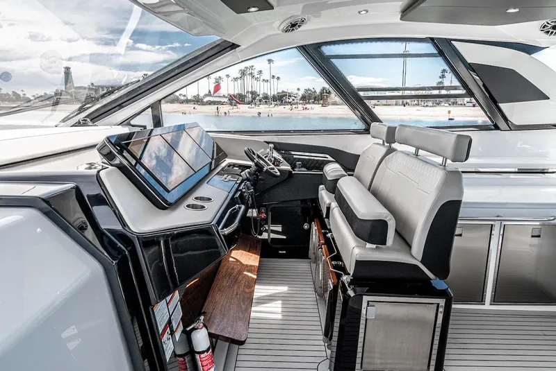 Slide: The Image of 2024 Cruisers Yachts 50 GLS helm station with modern navigation equipment and luxurious seating. - 43