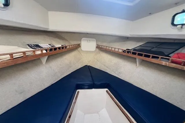 Slide: The Image of Interior cabin of 2007 Eastern 27 Islander boat with blue cushions and wooden shelves. - 10