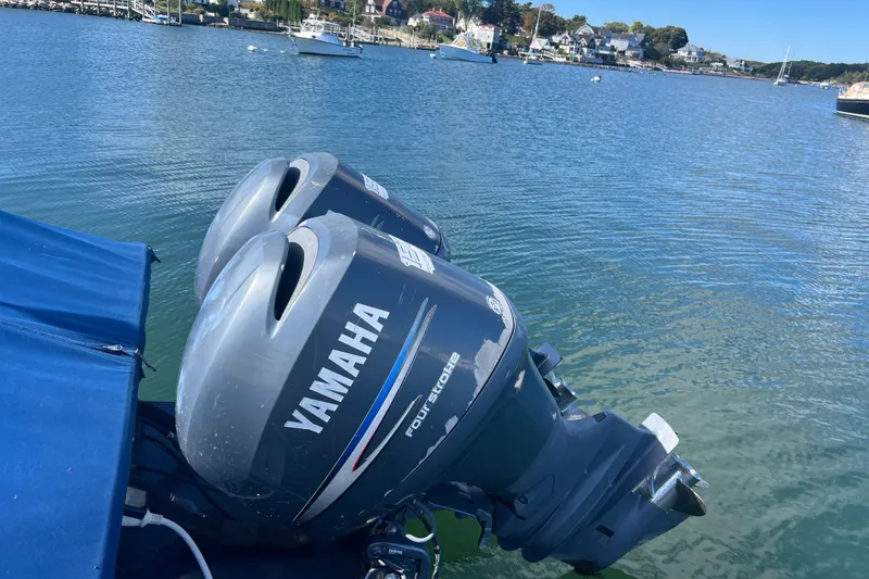 Slide: The Image of Twin Yamaha outboard motors on a 2007 Eastern 27 Islander boat in a scenic harbor. - 4