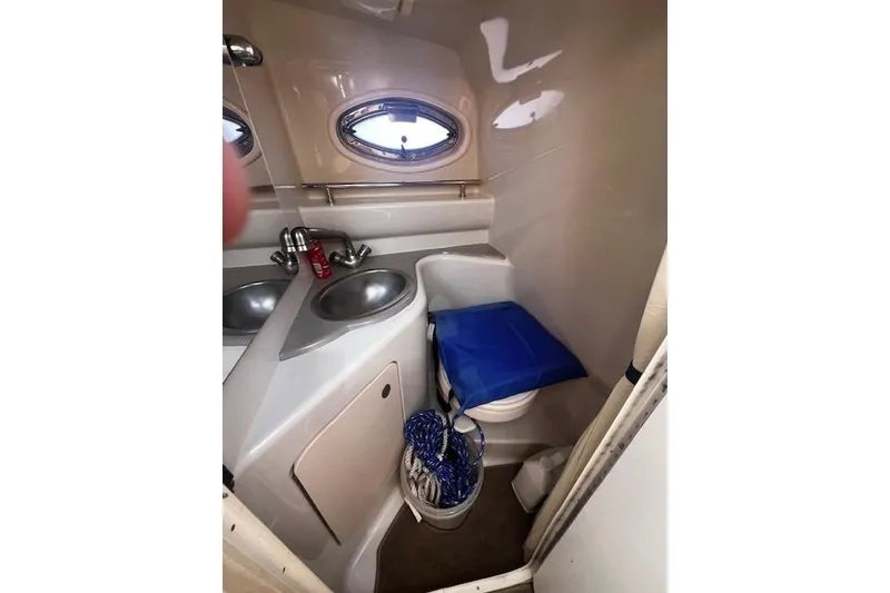 Slide: The Image of 2006 Searay 240 Sundancer boat bathroom with sink, toilet, and porthole window. - 10