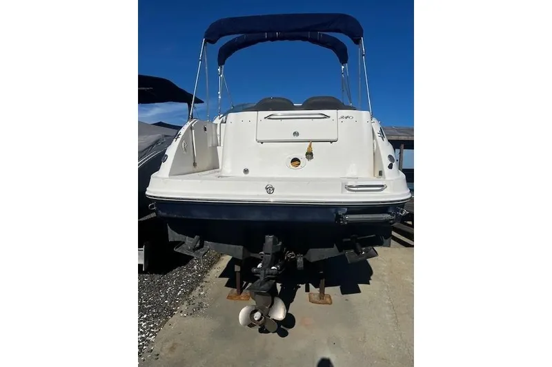 Slide: The Image of 2006 Searay 240 Sundancer boat, rear view, with blue canopy, on dry dock. - 4