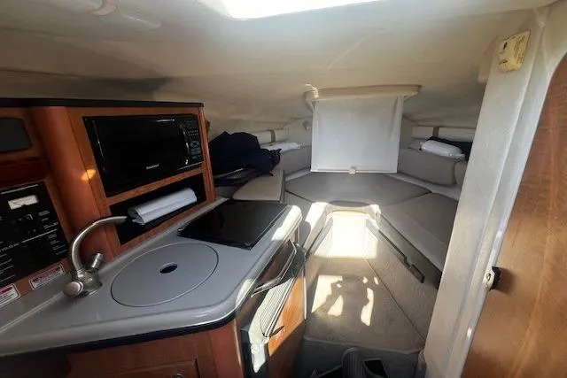 Slide: The Image of Interior of 2006 Searay 240 Sundancer boat with kitchenette and seating area. - 8