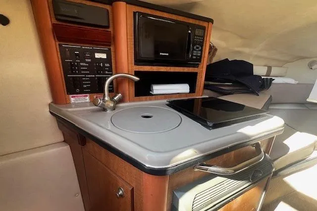 Slide: The Image of 2006 Searay 240 Sundancer cabin kitchenette with sink, microwave, and stove. - 9