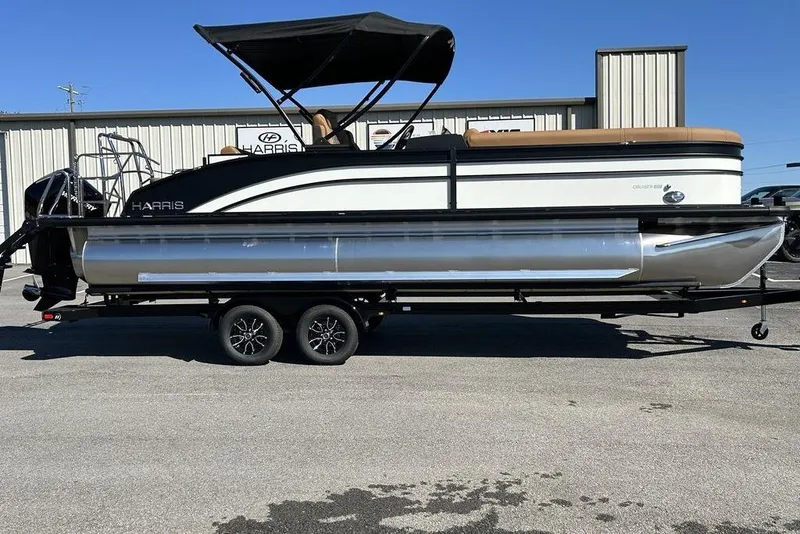 The Image of 2026 Harris Cruiser 250 LUX pontoon boat on trailer, featuring sleek design and canopy. - 1