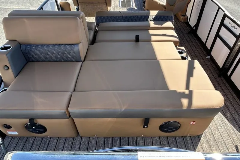 Slide: The Image of Luxurious seating on 2026 Harris Cruiser 250 LUX pontoon boat, featuring tan upholstery and cup holders. - 10
