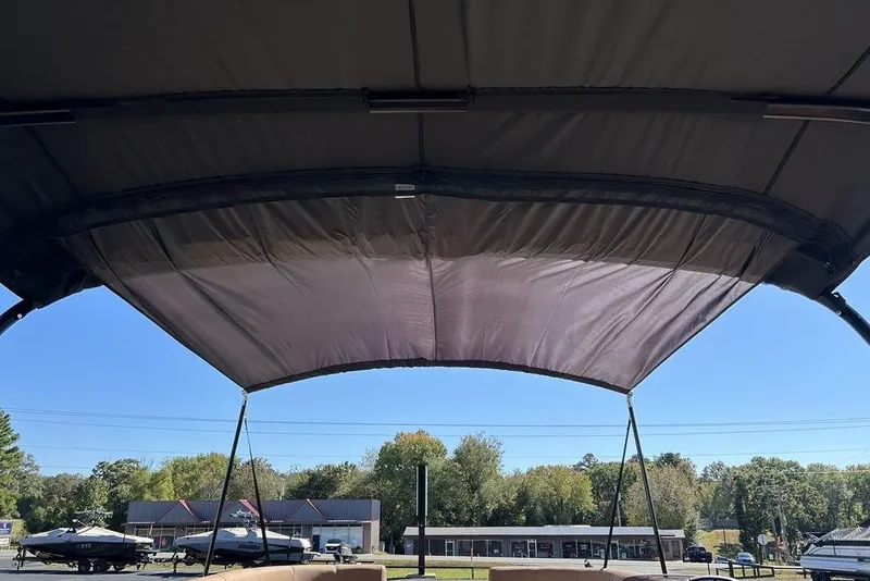 Slide: The Image of 2026 Harris Cruiser 250 LUX boat canopy with scenic outdoor view. - 12