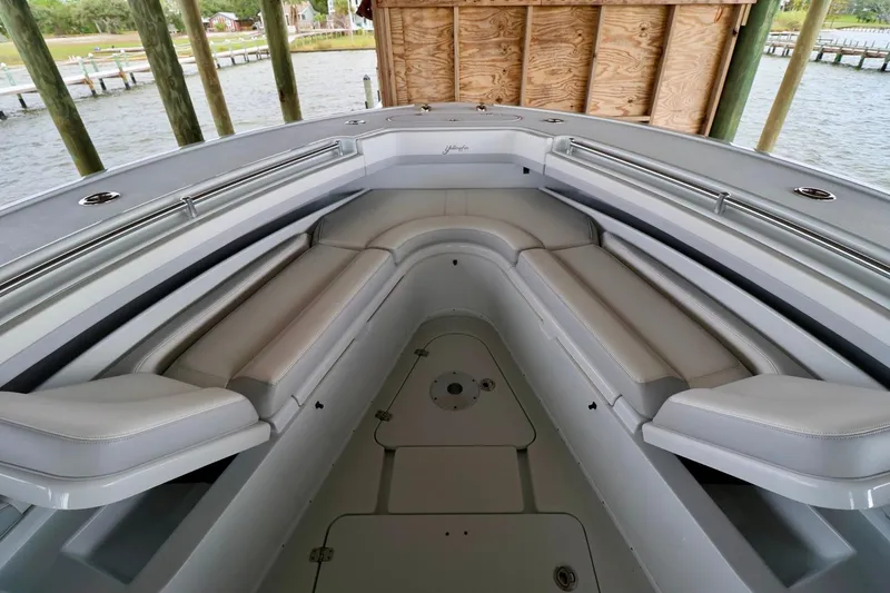 Slide: The Image of 2023 Yellowfin 42 Offshore boat interior with cushioned seating under a dock. - 10