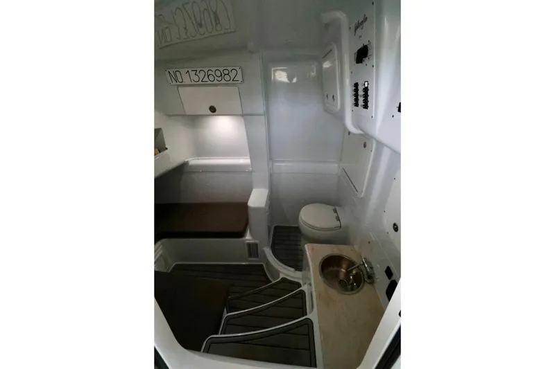 Slide: The Image of 2023 Yellowfin 42 Offshore cabin interior with seating, toilet, and sink. - 12