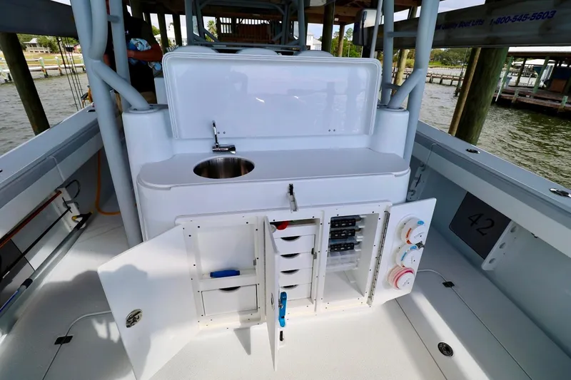 Slide: The Image of 2023 Yellowfin 42 Offshore boat interior with sink and storage compartments. - 19