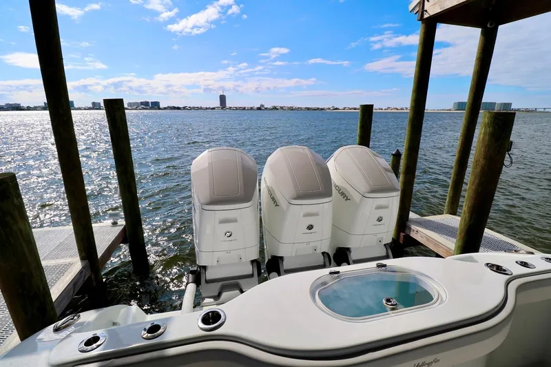 Slide: The Image of 2023 Yellowfin 42 Offshore boat with triple Mercury engines docked by the water. - 20