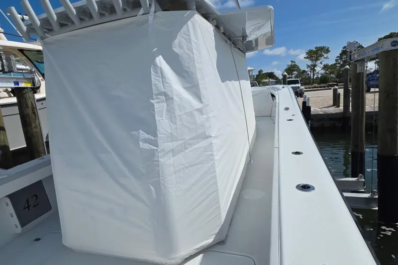 Slide: The Image of 2023 Yellowfin 42 Offshore boat docked, covered, with clear blue sky. - 4