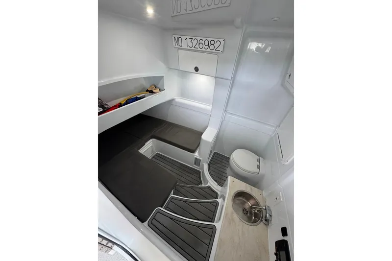 Slide: The Image of 2023 Yellowfin 42 Offshore cabin interior with seating, storage, sink, and toilet. - 6