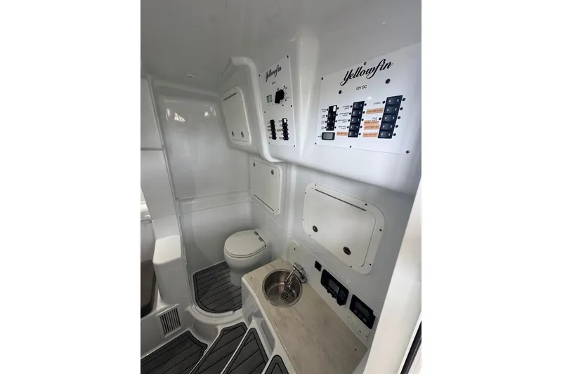 Slide: The Image of 2023 Yellowfin 42 Offshore boat interior with control panels and compact bathroom. - 7