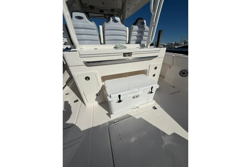 Slide: The Image of Interior of 2025 Robalo R300 Center Console boat, featuring storage compartments and fishing net. - 21