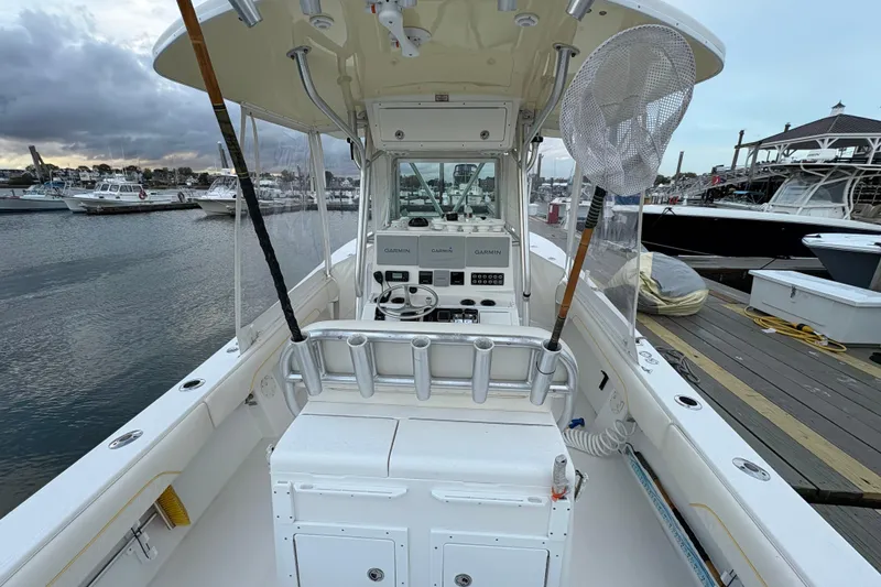 Slide: The Image of 2006 Regulator 32 Forward Seating boat at marina, featuring Garmin electronics and fishing gear. - 10