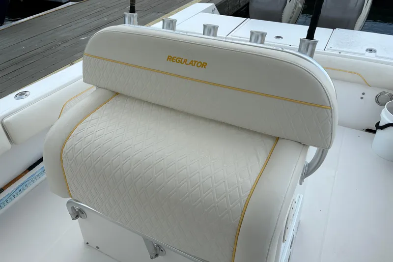 Slide: The Image of 2006 Regulator 32 Forward Seating boat with white cushioned seat and rod holders. - 12