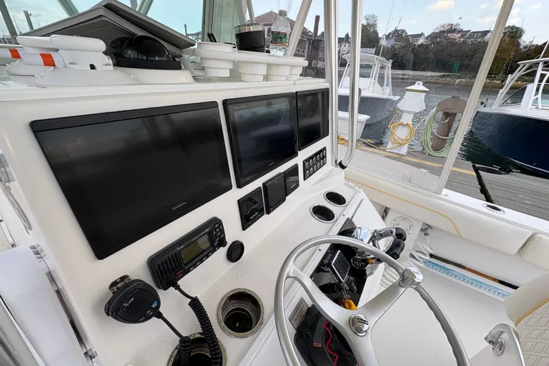 Slide: The Image of 2006 Regulator 32 Forward Seating boat dashboard with navigation screens and controls. - 15