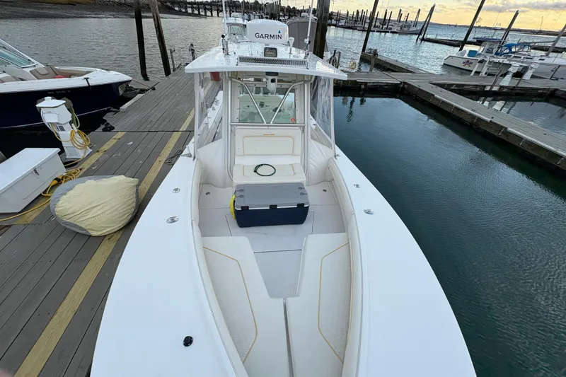 Slide: The Image of 2006 Regulator 32 Forward Seating boat docked at marina, featuring spacious deck and seating. - 26