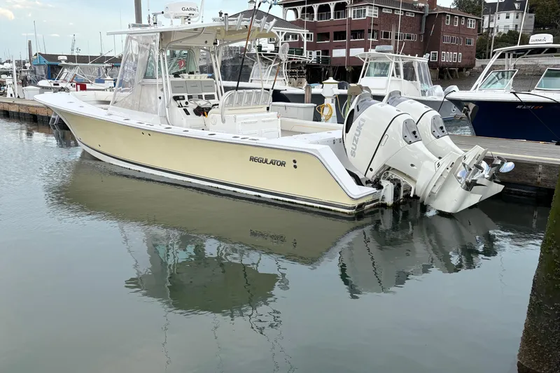 Slide: The Image of 2006 Regulator 32 Forward Seating boat docked in marina with twin Suzuki engines. - 4