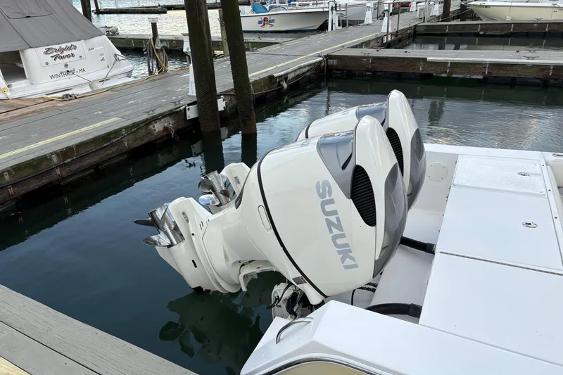 Slide: The Image of 2006 Regulator 32 Forward Seating boat with twin Suzuki outboard motors docked at marina. - 6