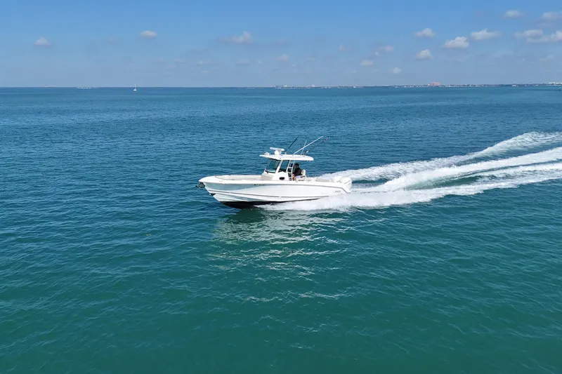 Slide: The Image of 2017 Boston Whaler 330 Outrage cruising on open blue water. - 2