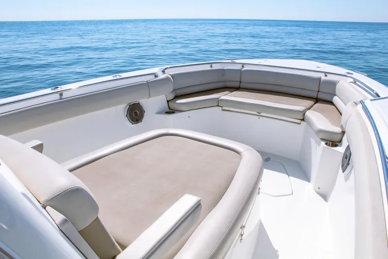 Slide: The Image of 2017 Boston Whaler 330 Outrage boat interior with cushioned seating on open water. - 5