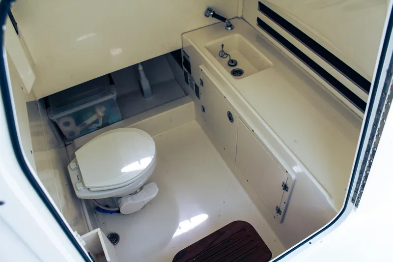 Slide: The Image of 2017 Boston Whaler 330 Outrage boat bathroom with toilet and sink. - 9