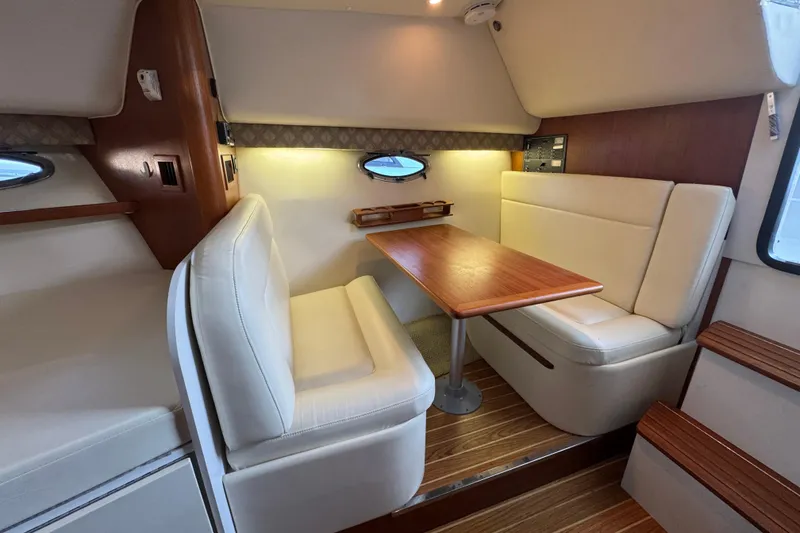 Slide: The Image of 2005 Tiara Yachts 2900 Open cabin interior with dining area and wooden table. - 11