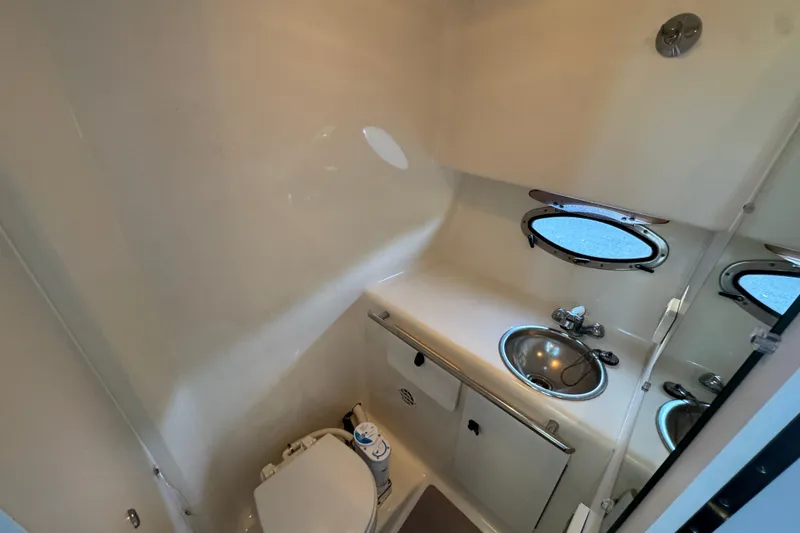 Slide: The Image of 2005 Tiara Yachts 2900 Open bathroom with sink, toilet, and porthole window. - 15