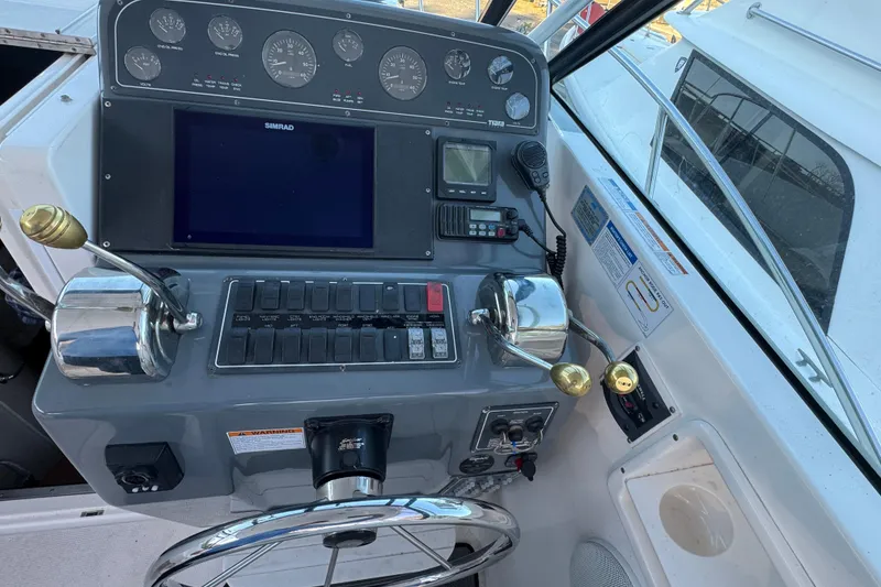 Slide: The Image of Control panel of a 2005 Tiara Yachts 2900 Open, featuring navigation instruments and steering wheel. - 3