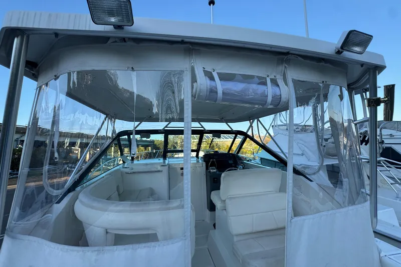 Slide: The Image of 2005 Tiara Yachts 2900 Open boat interior with clear enclosures and seating. - 6