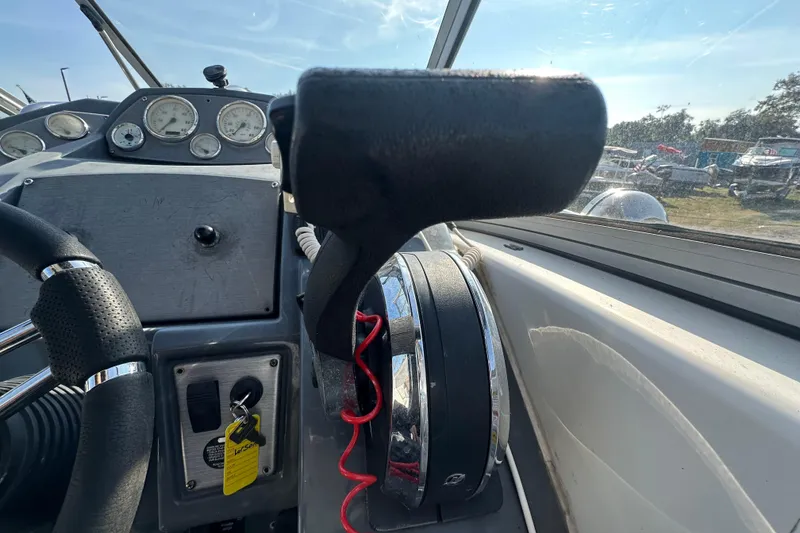 Slide: The Image of 2014 Larson Cabrio 265 boat dashboard with steering wheel and control panel. - 14