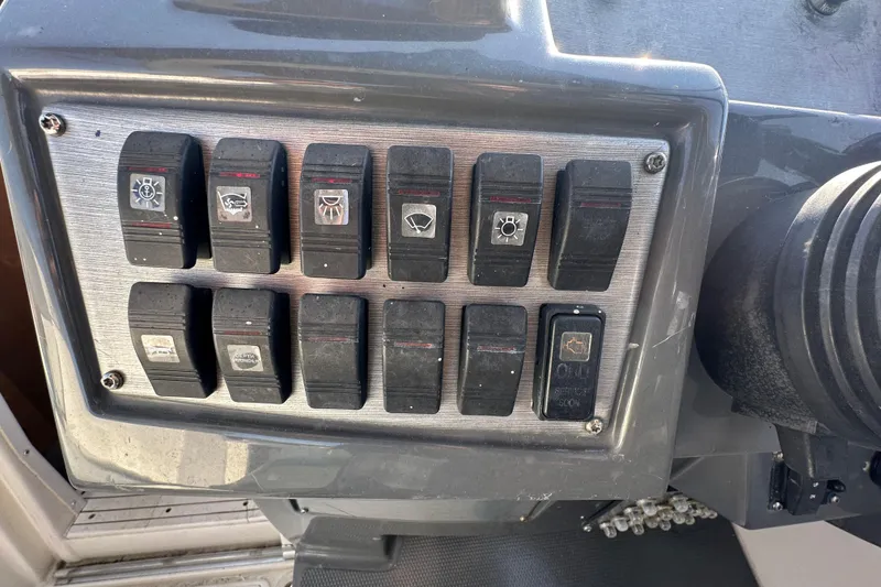 Slide: The Image of Control panel of a 2014 Larson Cabrio 265 boat with various switches. - 16